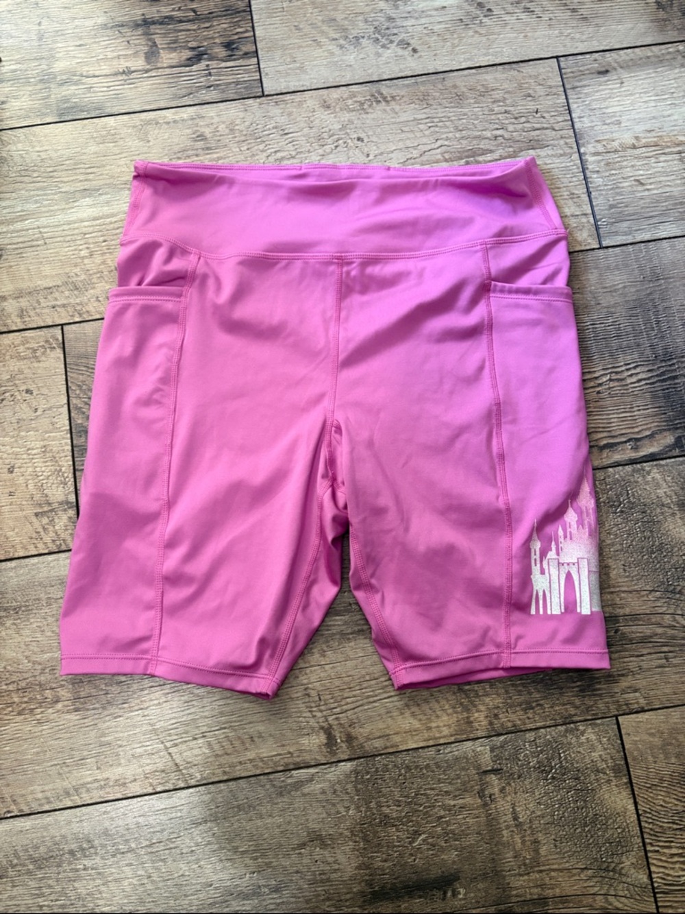 Pink Disney workout shorts featuring sparkly Cinderella castle